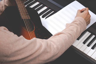 male songwriter writing song on blank music sheet